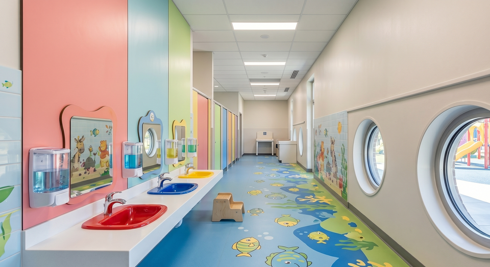 Kindgerechter Sanitärbereich: saubere Waschbecken in niedriger Höhe, desinfizierte Griffe und gefüllte Spender